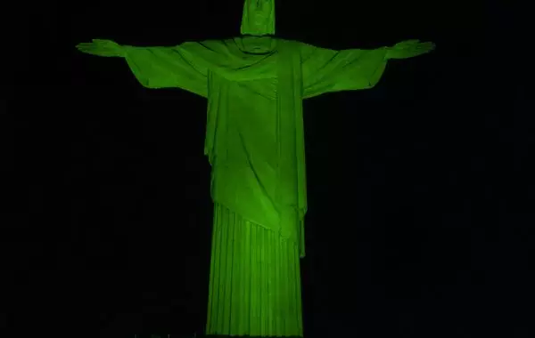 Cristo Redentor iluminado de verde alerta para doença rara confundida com esclerose múltipla